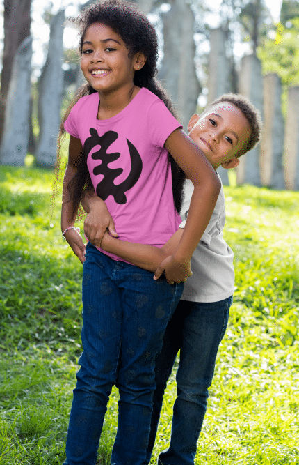 Two children are hugging in a park.