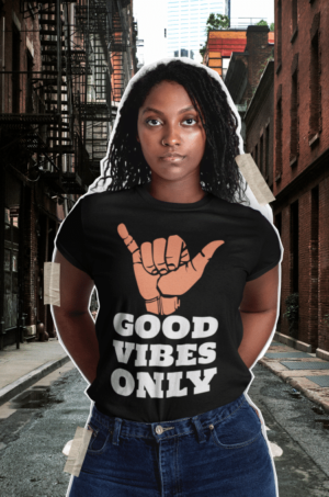 A woman standing in the street wearing a shirt with an image of a hand sign.