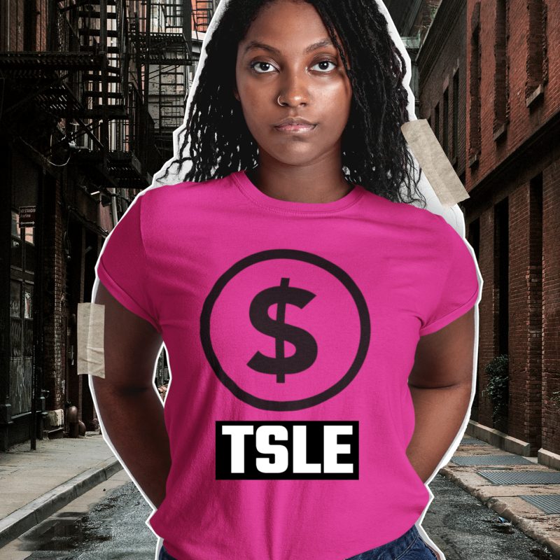 A woman standing on the street wearing a pink shirt.
