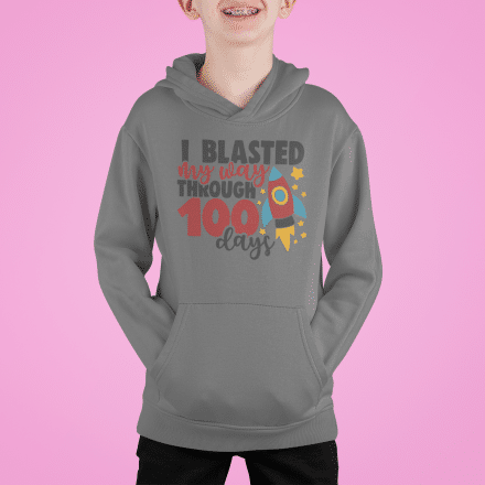 A young boy wearing a gray hoodie with the words " i blasted 9 0 times through 5 0 0 days ".