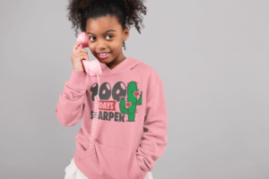 A girl holding onto a phone and wearing a pink hoodie