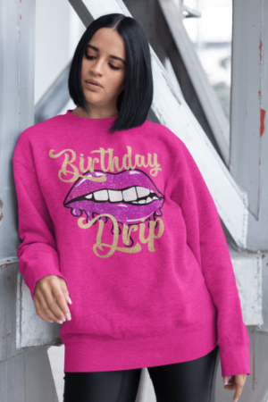 A woman wearing a purple sweatshirt with a mouth and lips.