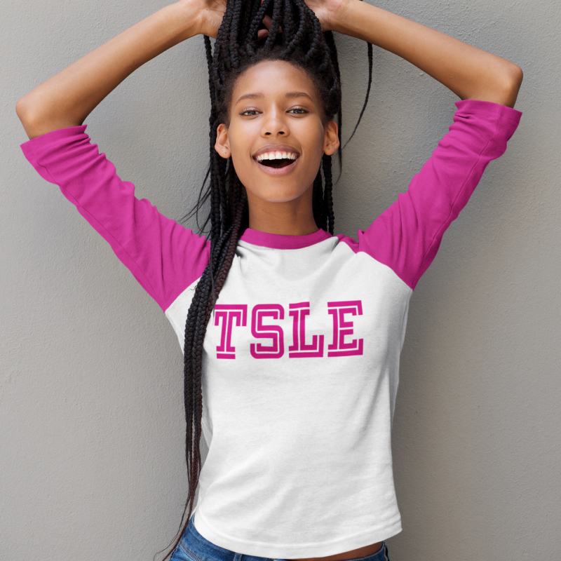 A girl with long hair is wearing a white shirt and pink letters.
