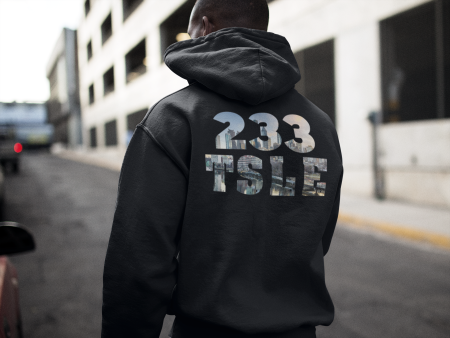 A man wearing a black hoodie with the words " 2 3 3 tstle ".