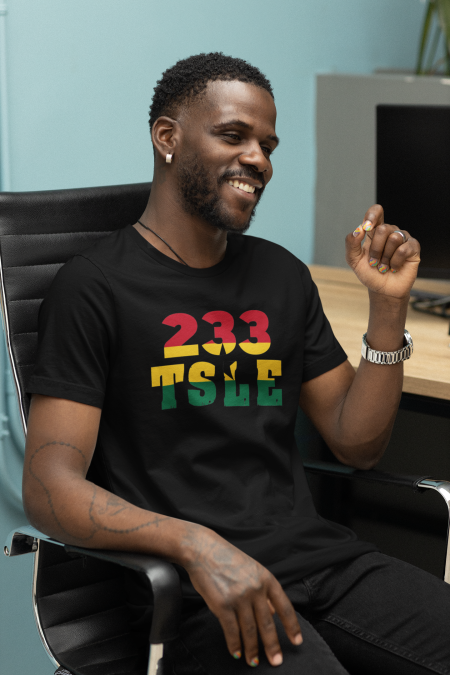 A man sitting in a chair wearing a t-shirt with the number 2 3 3 tole.