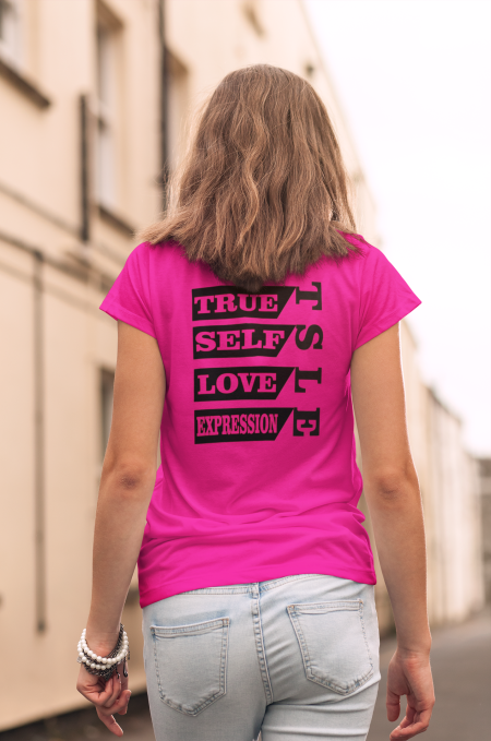 A woman wearing jeans and pink shirt with words