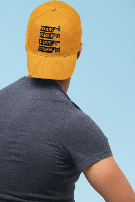 A man wearing a yellow hat with the words " only love wins ".